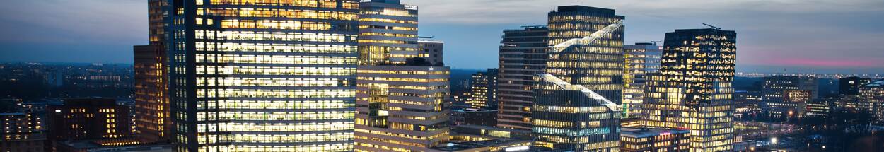 Zuidas in het donker met verlichte kantoren